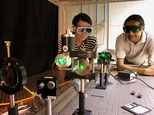 Twee futuristisch ogende mannetjes aan de slag met laser en dvd's Twee futuristisch ogende mannetjes aan de slag met laser en dvd's