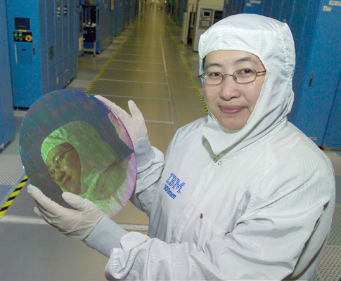 IBM-medewerker met een wafer met Cell-chips