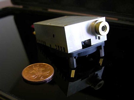 Laserbeamer naast two pence muntstuk