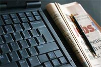 Krant naast laptop