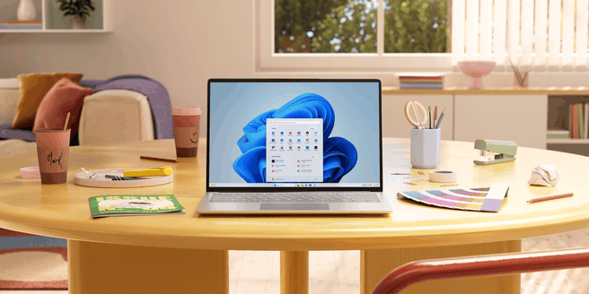 Windows 11, laptop op tafel, startmenu. Bron: Microsoft