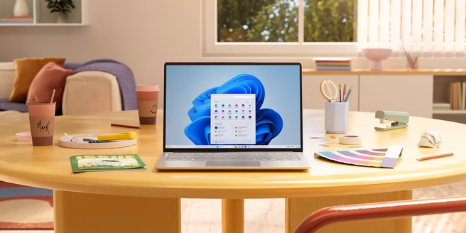 Windows 11, laptop op tafel, startmenu. Bron: Microsoft